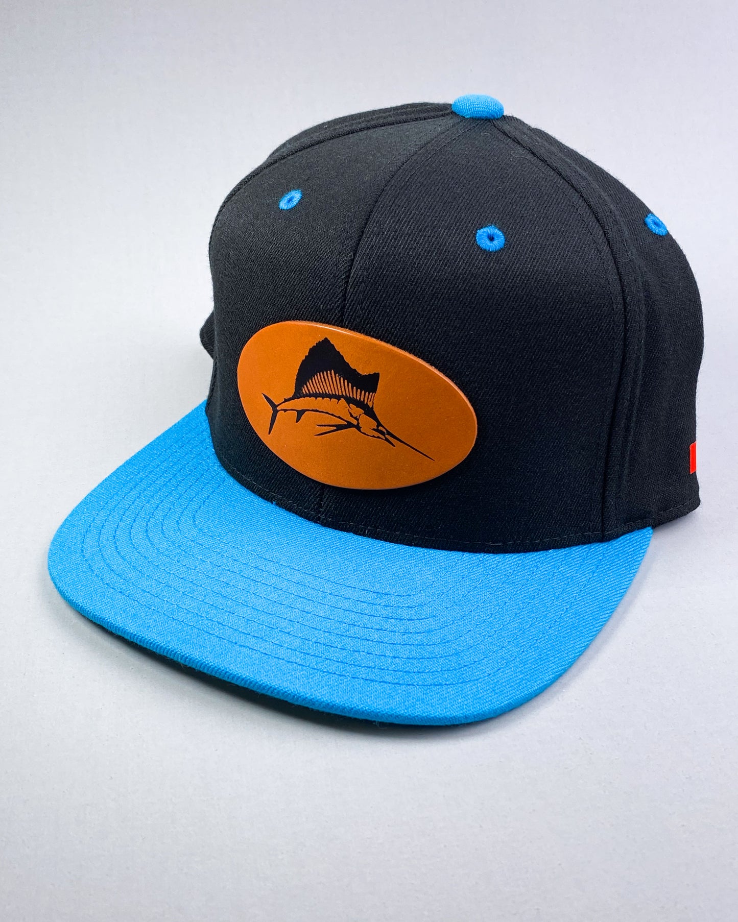 Bravo Cay hat in turquoise/black with sailfish design leather patch